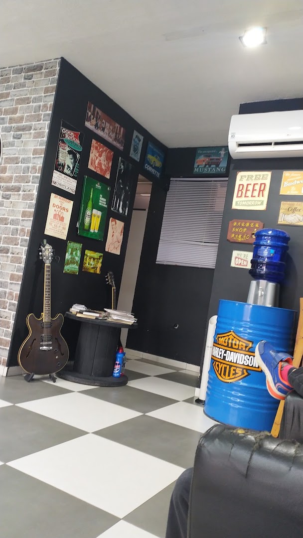 Canto de espera da barbearia com discos, guitarra e decoração vintage